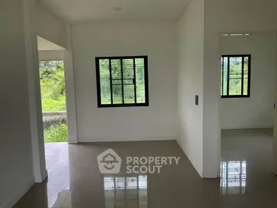 Bright interior with large windows and garden view, perfect for a serene living space.