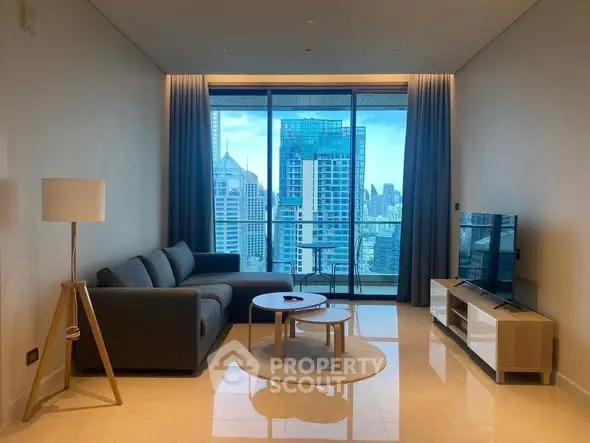 Modern living room with city view, featuring sleek furniture and floor-to-ceiling windows.