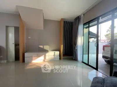 Spacious modern living room with large sliding glass doors and sleek tile flooring.