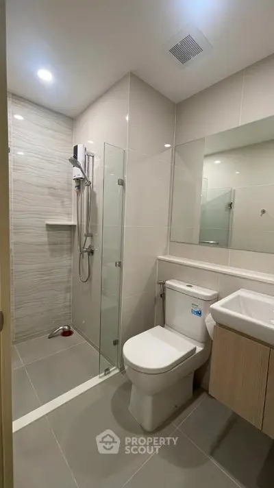 Modern bathroom with glass shower and sleek fixtures in contemporary apartment