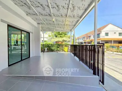 Spacious covered balcony with modern tiles and railing, perfect for outdoor relaxation.