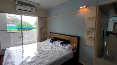Cozy bedroom with balcony access and modern air conditioning unit