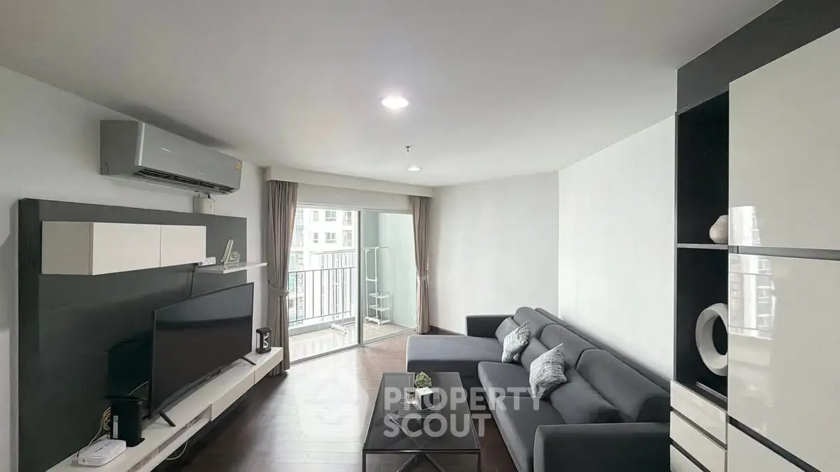 Modern living room with sleek furniture and balcony access in a stylish apartment.