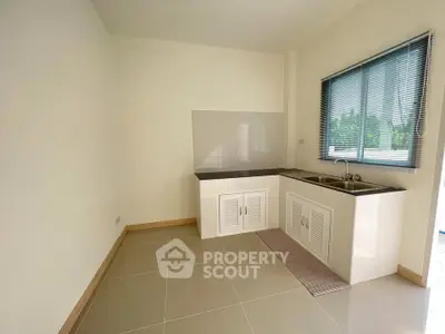 Modern minimalist kitchen with sleek cabinetry and large window