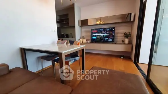 Modern living room with sleek furniture and wall-mounted TV, featuring a cozy dining area and stylish decor.