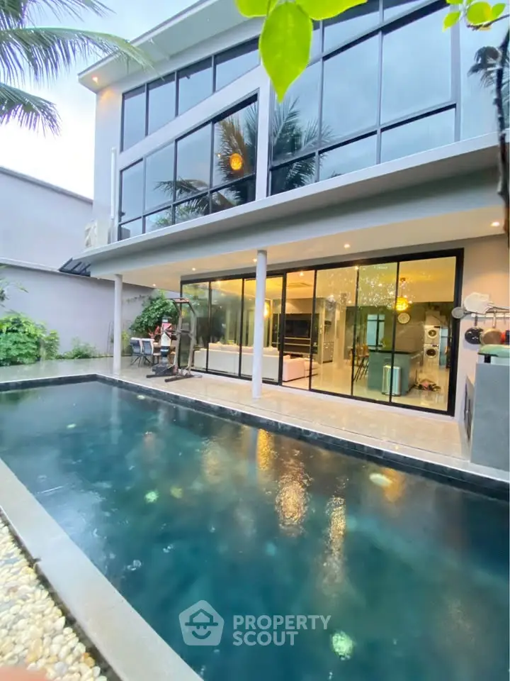Luxurious modern home with private pool and spacious glass facade, perfect for elegant living.