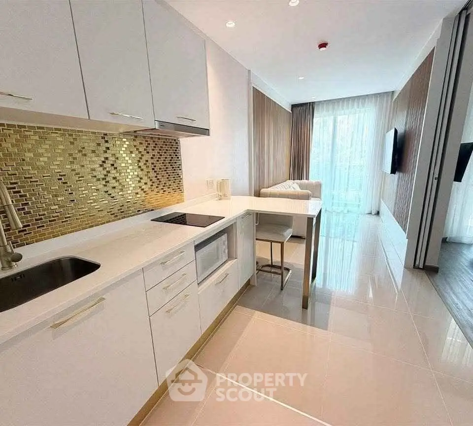 Modern kitchen with sleek white cabinets and stylish backsplash in open layout apartment.