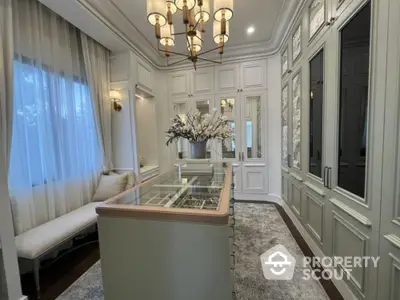 Elegant kitchen with classic white cabinetry, sophisticated chandelier, and a cozy dining nook bathed in natural light.