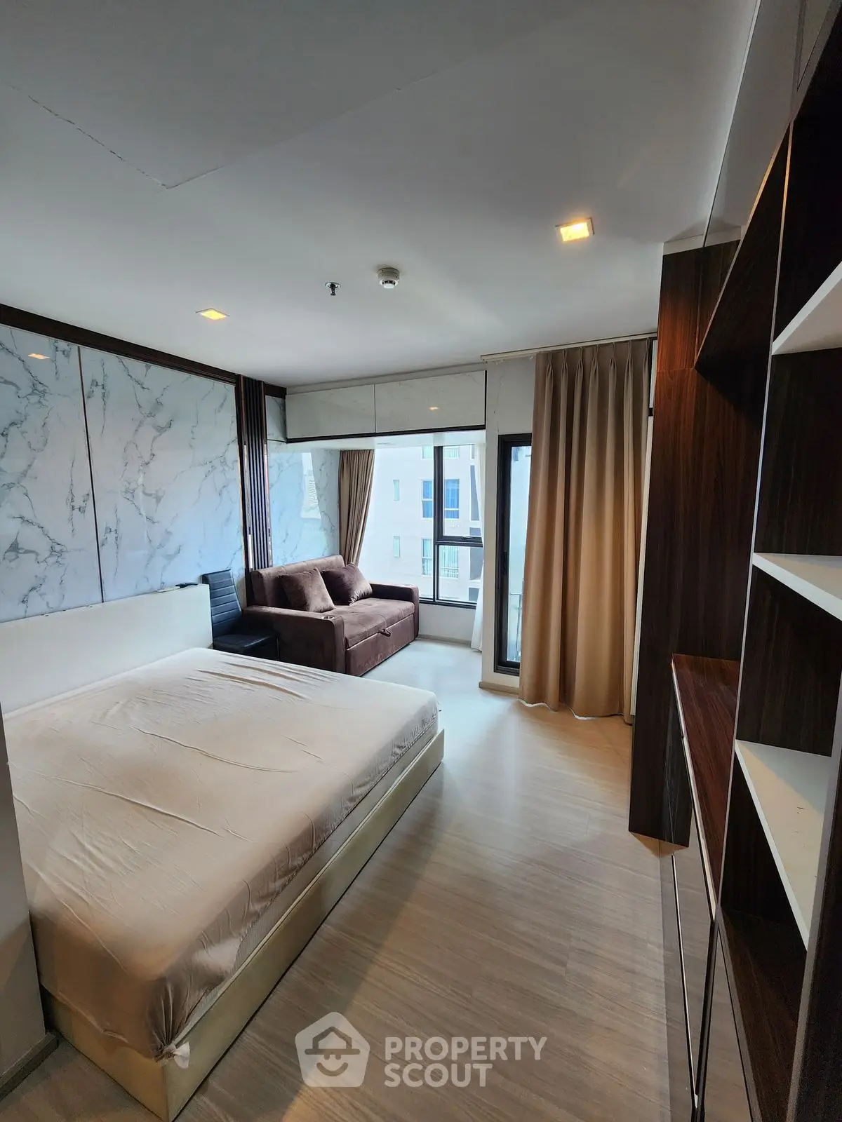 Spacious modern bedroom with elegant decor and large windows for natural light.
