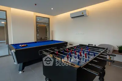 Modern game room with pool table and foosball, ideal for entertainment.