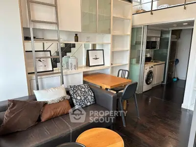 Modern loft apartment with stylish living area and compact kitchen featuring washing machine.