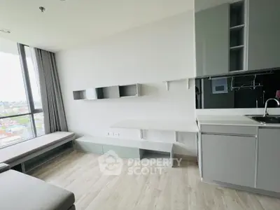 Modern living room with sleek kitchen and panoramic city view, featuring minimalist design and ample natural light.