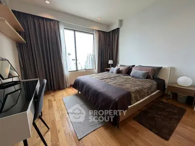 Spacious bedroom with modern decor and large window offering city views, perfect for urban living.