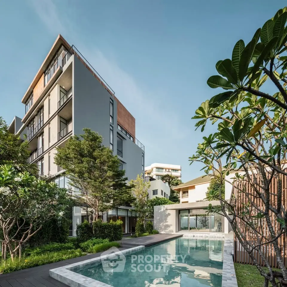 Modern apartment building with lush garden and inviting pool area, perfect for luxury living.