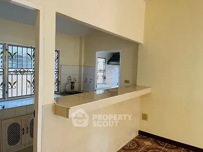 Charming open kitchen with tiled counter and window view, perfect for modern living.