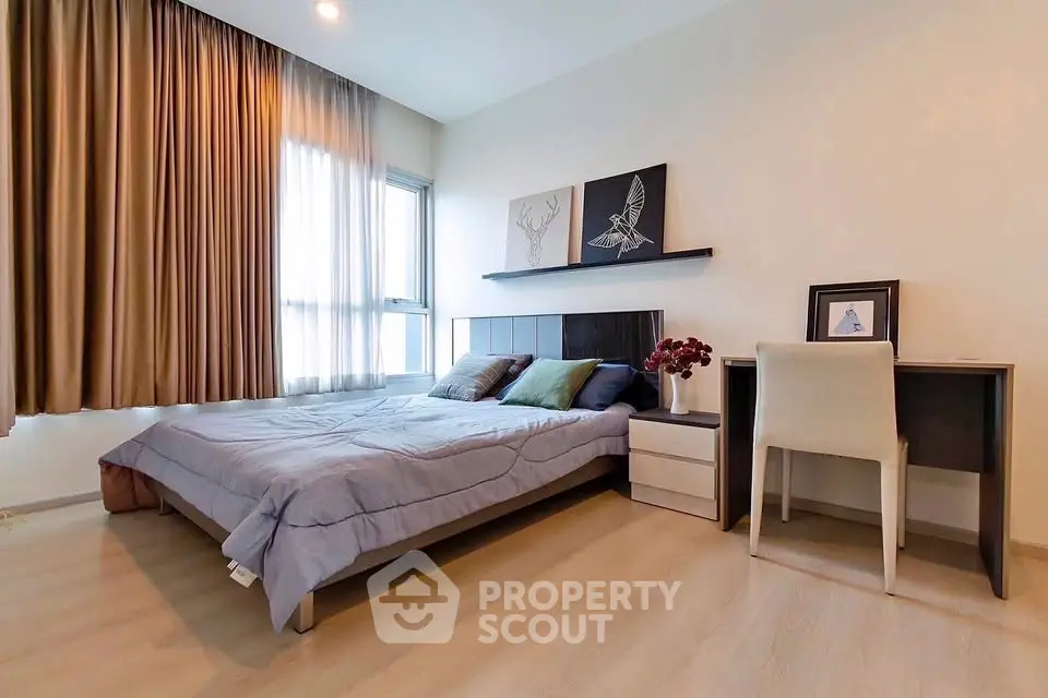 Modern bedroom with stylish decor and natural light, featuring a cozy bed and a sleek desk area.