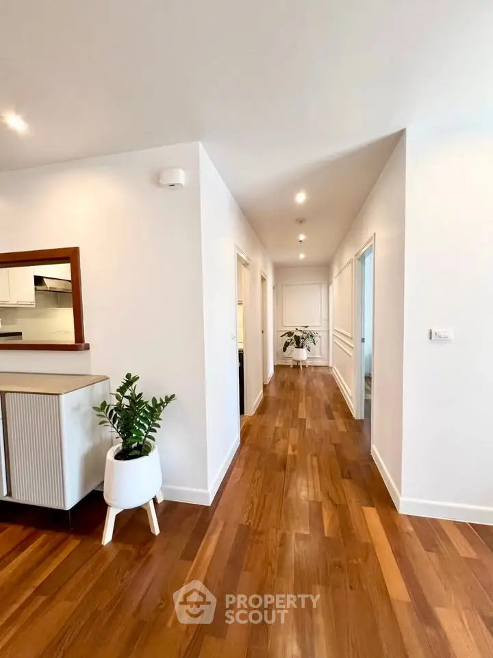 Spacious hallway with wooden flooring and modern decor in a stylish apartment.