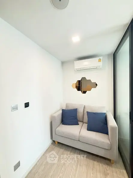 Cozy small living room with modern sofa and air conditioning, perfect for compact urban living.