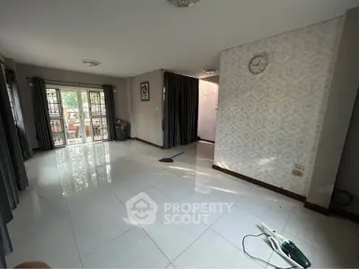 Spacious living room with large windows and elegant tile flooring