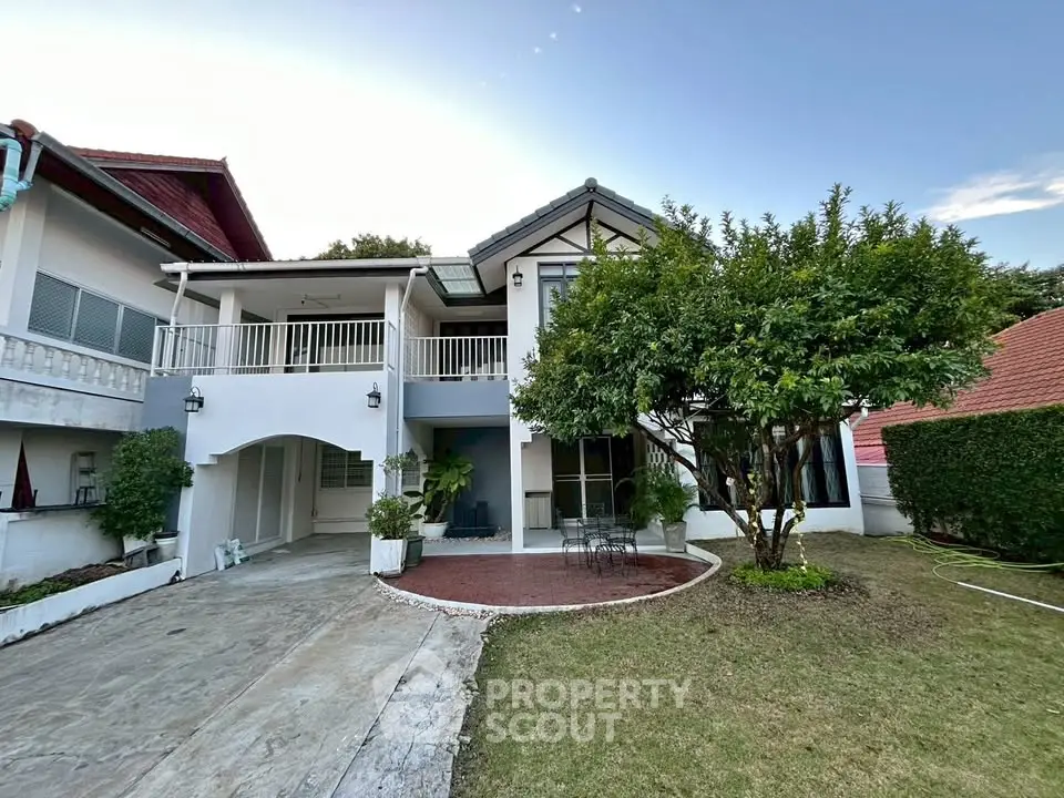 Charming two-story house with lush garden and spacious driveway in serene neighborhood.