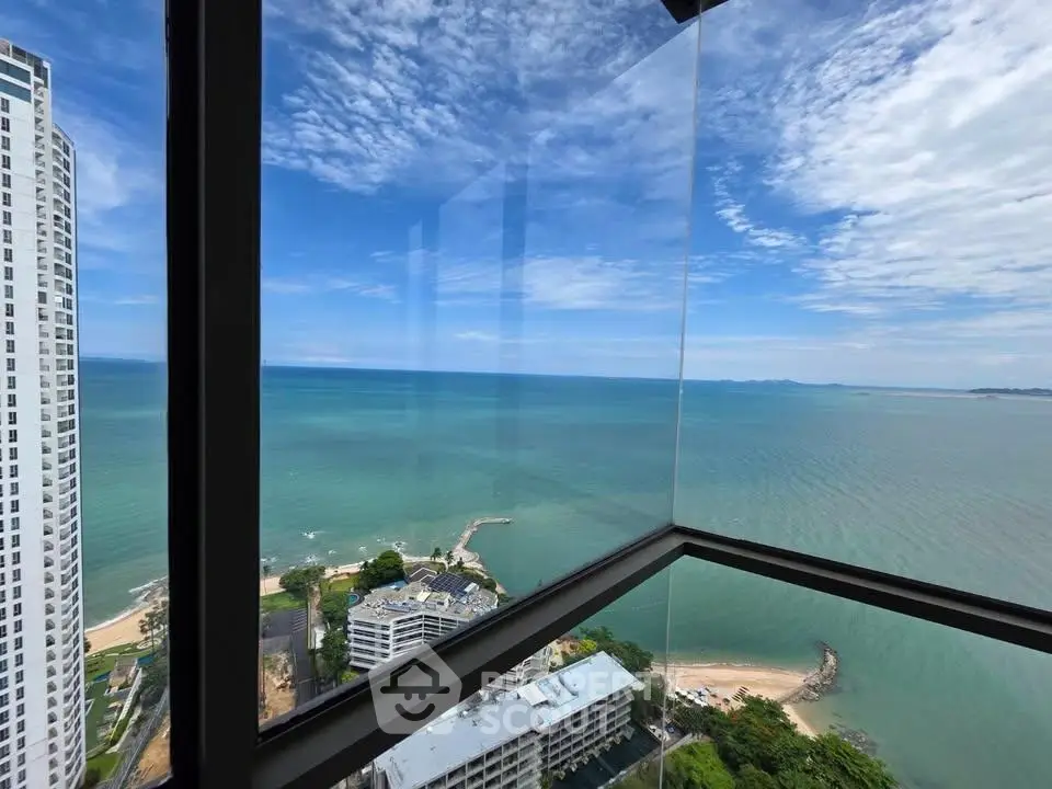 Stunning ocean view from high-rise balcony with clear blue skies and serene waters.