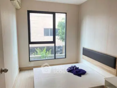Minimalist bedroom with large window and natural light