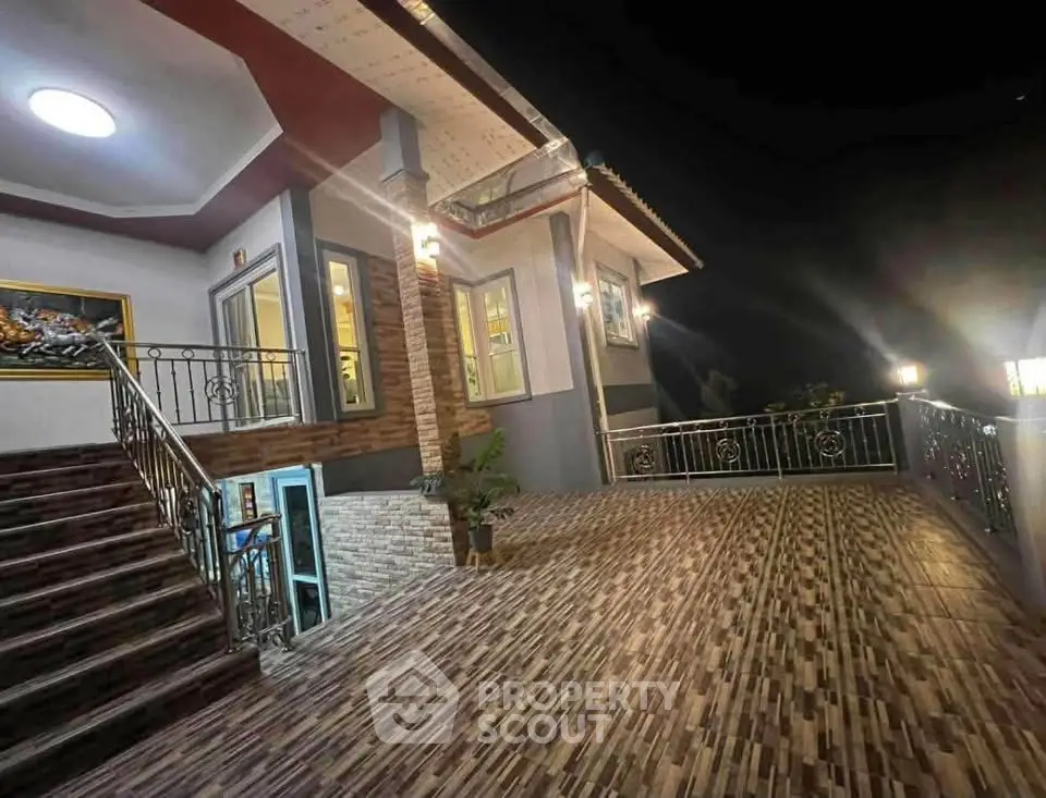 Elegant night view of a modern house exterior with spacious tiled terrace and stylish lighting.