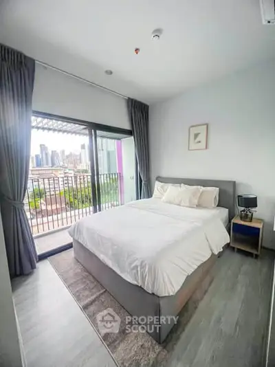 Modern bedroom with city view and balcony access in a stylish apartment.