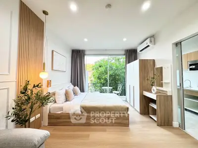 Modern bedroom with balcony access, featuring stylish decor and natural light, perfect for urban living.