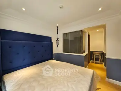 Elegant bedroom with plush blue headboard and ambient lighting