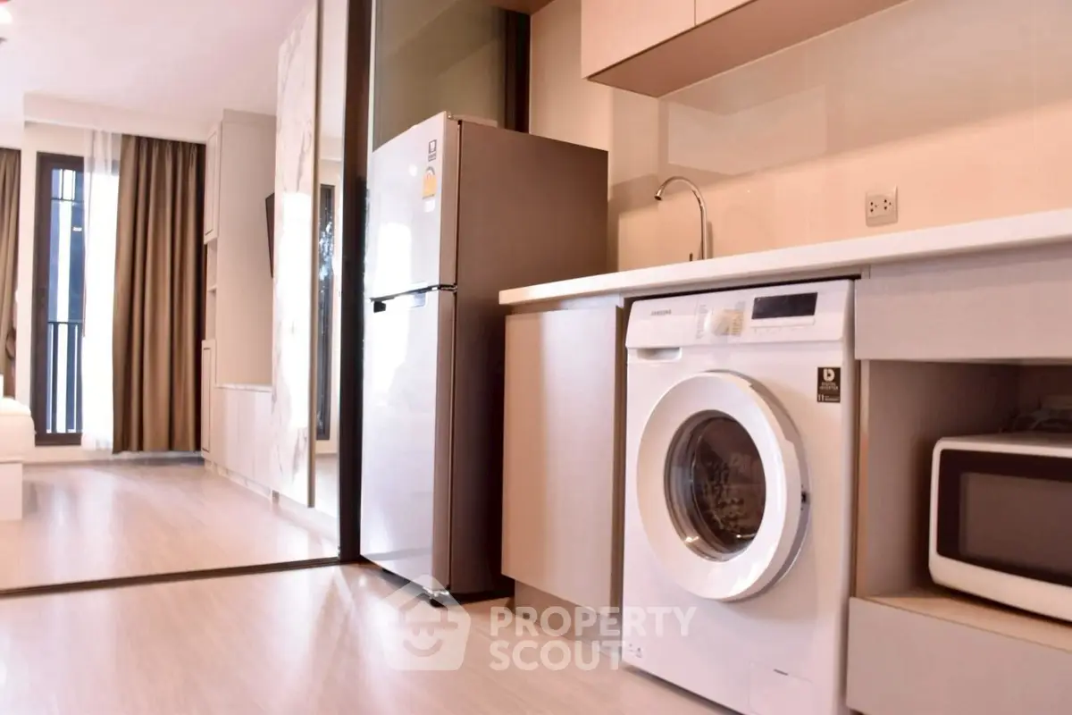 Modern kitchen with washing machine and fridge in stylish apartment