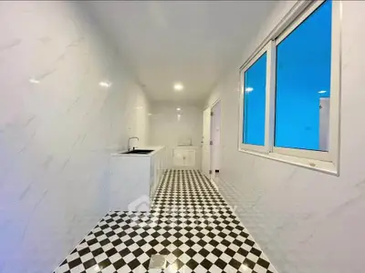 Sleek modern kitchen with checkered floor and white cabinetry