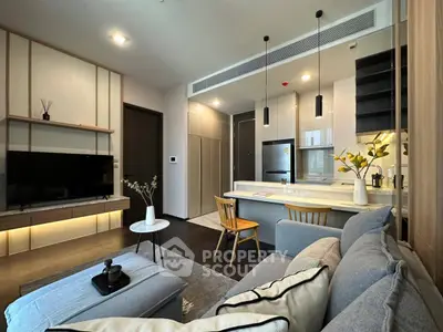 Modern living room with open kitchen, stylish decor, and cozy seating area in a contemporary apartment.