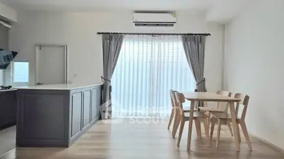 Modern kitchen and dining area with natural light and sleek design.