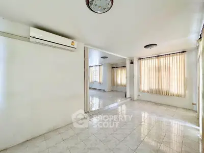 Spacious living room with tiled floors and natural light