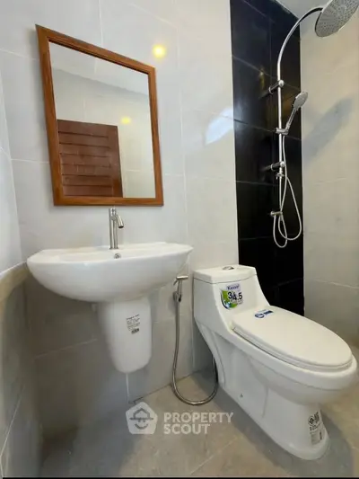 Modern bathroom with sleek fixtures and elegant design, featuring a wall-mounted sink and contemporary shower.