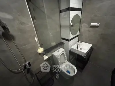 Modern bathroom with sleek design, featuring a glass shower and contemporary fixtures.