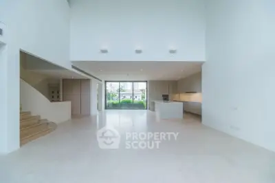 Spacious modern open-plan living area with sleek kitchen and large windows offering natural light.