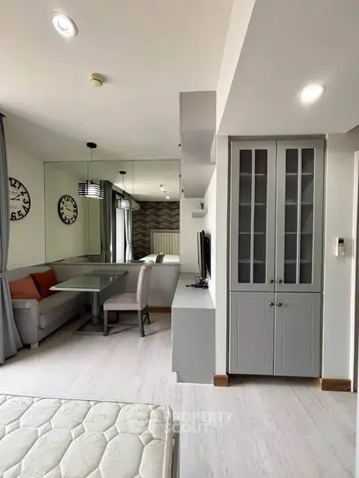 Modern living room with stylish furniture and built-in storage, featuring a cozy dining nook and elegant decor.