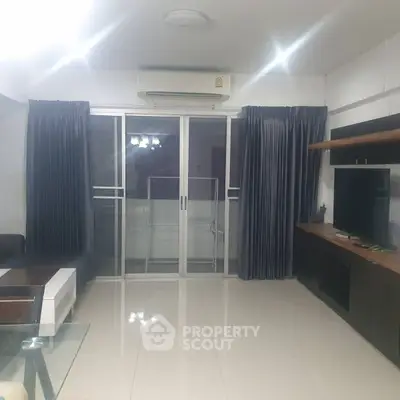 Spacious living room with modern furnishings and large sliding glass doors.