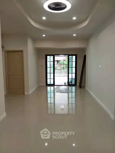 Spacious modern living room with glossy floors and large windows for natural light.