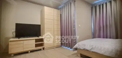 Cozy bedroom with modern wooden furniture and large windows with curtains.