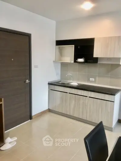 Modern compact kitchen with sleek cabinets and tiled backsplash