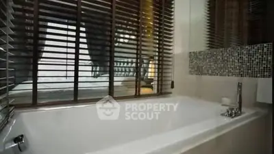 Modern bathroom with large bathtub and stylish window blinds