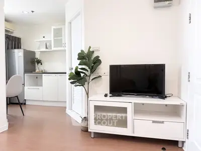 Modern living room with sleek TV stand and view into stylish kitchen
