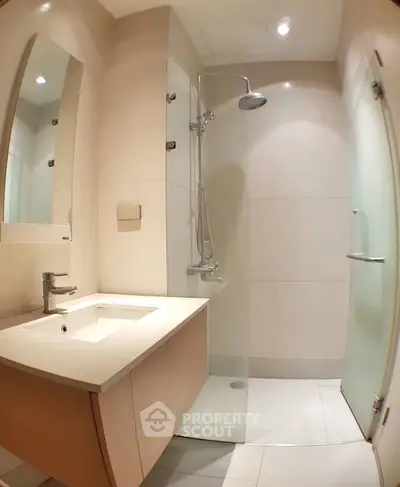 Modern bathroom with sleek shower and elegant vanity in contemporary apartment.