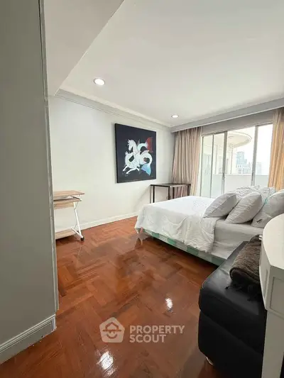 Spacious bedroom with modern decor and city view balcony access.