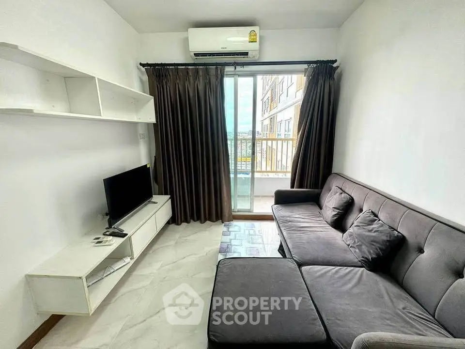 Modern living room with sleek sofa and balcony view in urban apartment.