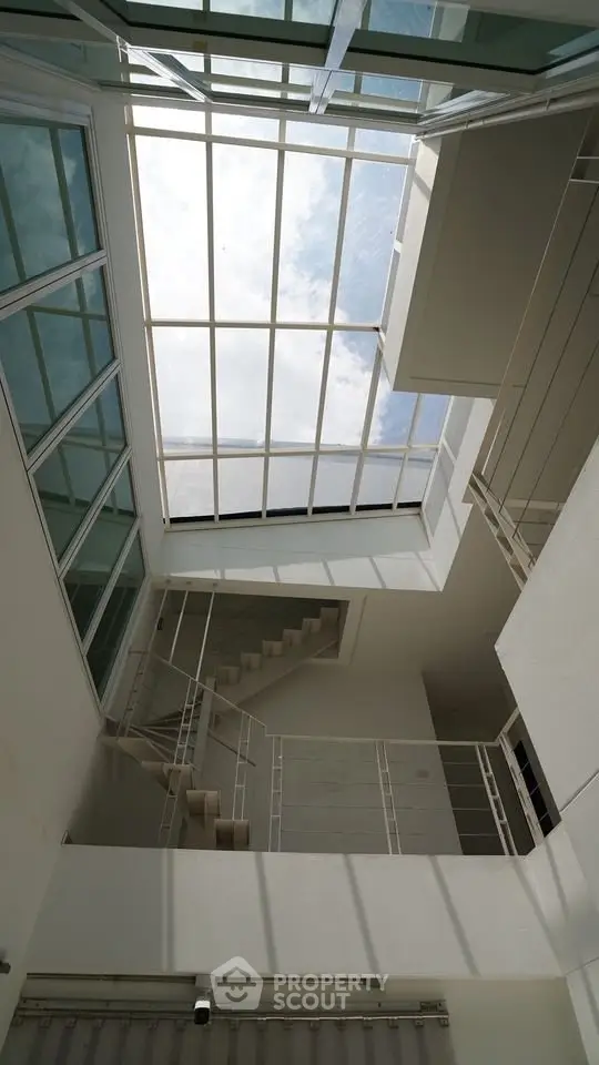 Modern atrium with skylight and spiral staircase in contemporary building