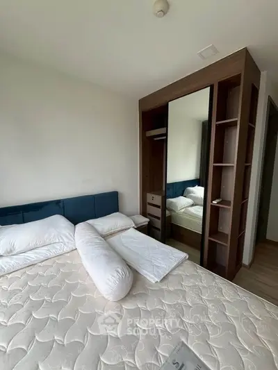 Modern bedroom with stylish mirrored wardrobe and cozy bed setup